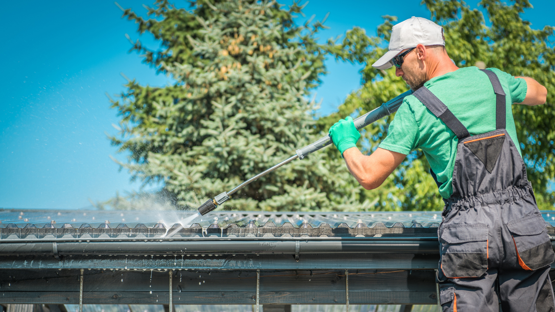 Technician power washing gutters during gutter cleaning